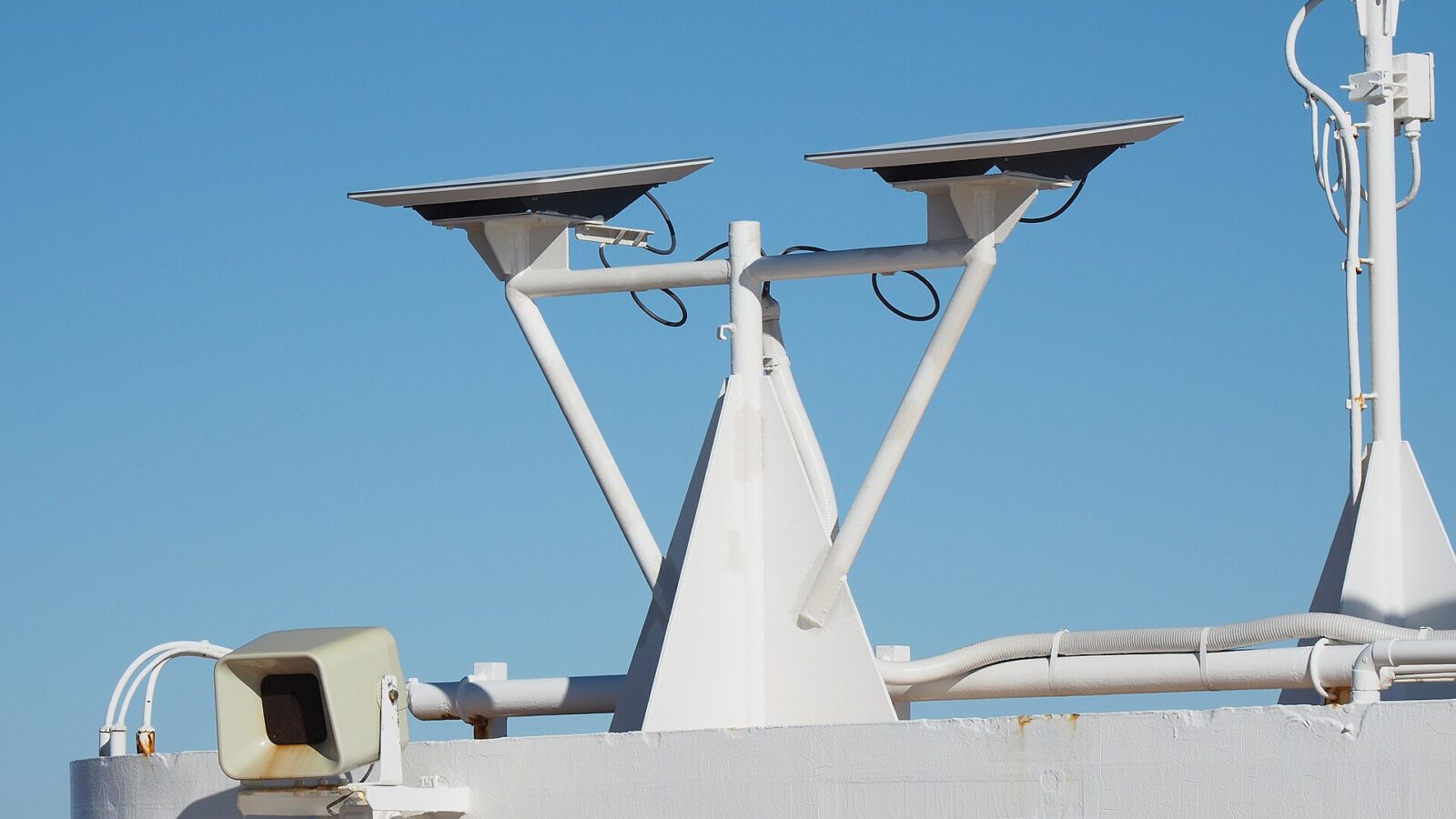 Due antenne piatte Starlink montate su un supporto bianco sul ponte di una nave, sotto un cielo azzurro