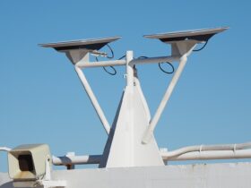 Due antenne piatte Starlink montate su un supporto bianco sul ponte di una nave, sotto un cielo azzurro